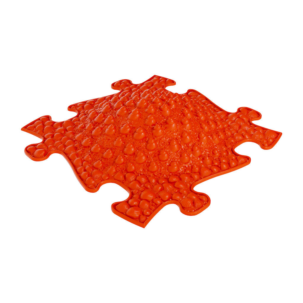 A red mat for children's motor skill development and sensory experiences.