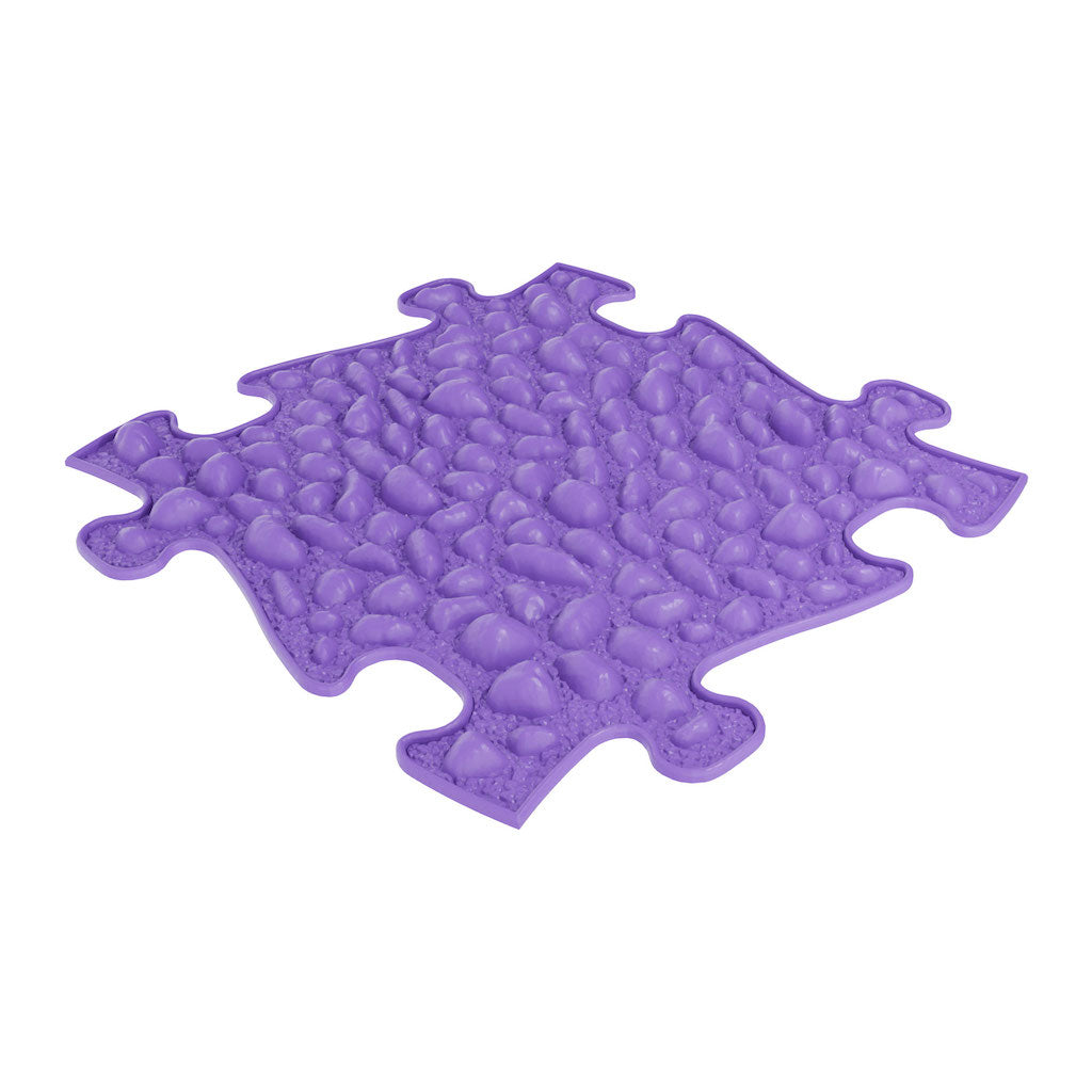 A purple Pebbles sensory playmat with a puzzle piece shape and a textured surface designed to provide soft and firm sensations.
