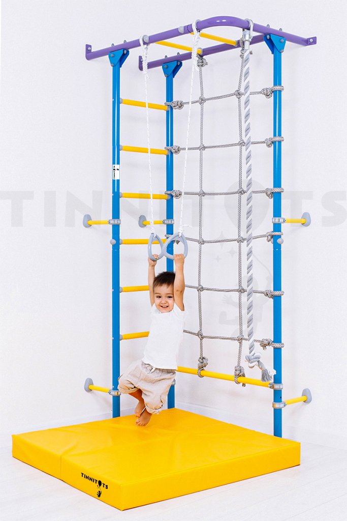 child hanging on the rings attached to indoor monkey bars
