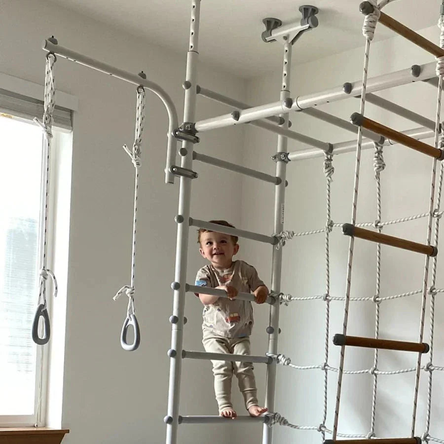 A toddler climbing a monkey bar equipment in Australia by Tinnitots