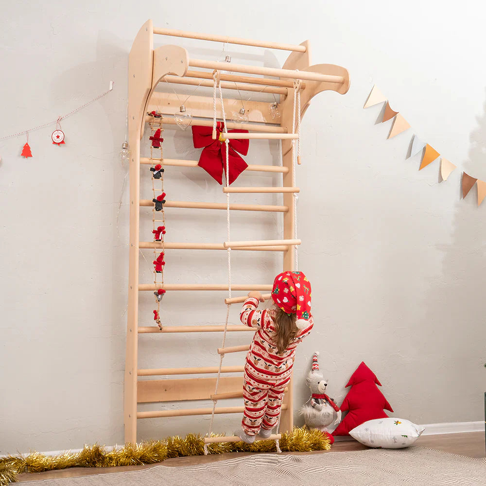 a girl of 4 years old trying to climb on a wooden ladder which is hanging on a wooden swedish kids wallbars by Tinnitots