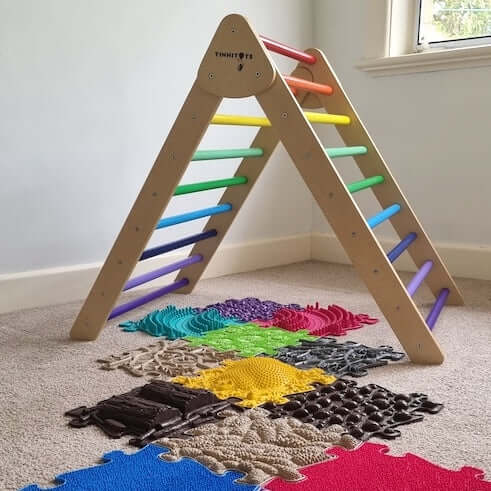 A bright and inviting image of Tinnitots rainbow foldable pikler for toddlers from 2 to 4 years old.