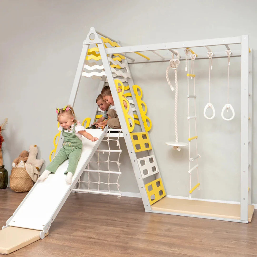 three young siblings playing on a wooden swing and play set with monkey bars in yellow and white colour with slide by Tinnitots