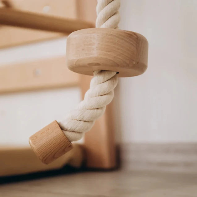 Close-up of a wooden baby toy with a rope, on a neutral background