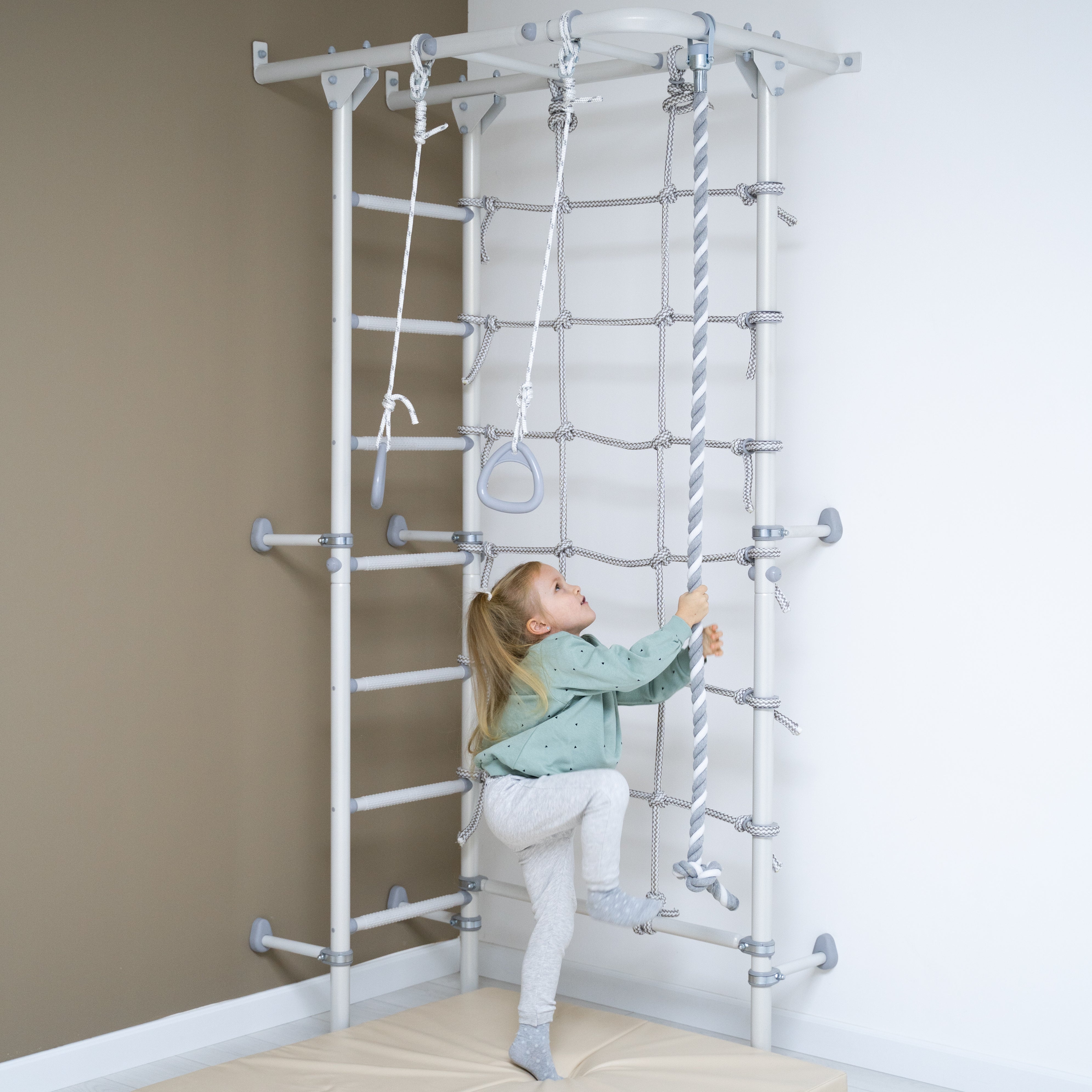 Monkey bars, gymnastics rings, spider net and climbing frame for kids in home play gyms.